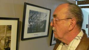 Pete Lamontagne examines a historical photo of mill workers who toiked in the same buildings where he and his father worked.