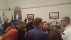 Matt Lauzon (far left) taunts and tries to distract Mayor Alan Casavant during a press conference.